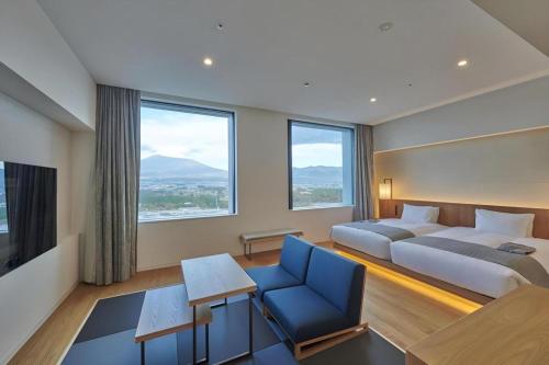 a hotel room with a bed and a couch and windows at HOTEL CLAD in Gotemba