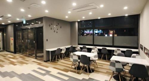 ein Restaurant mit Tischen und Stühlen in einem Raum in der Unterkunft Urban Place Inn Kokura in Kitakyūshū