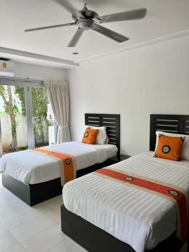 a bedroom with two beds and a ceiling fan at Villa 3 Tropical Oasis with Private Pool in Plai Laem