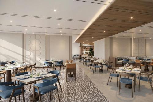 a rendering of a restaurant with tables and chairs at Marriott Hotel Production City, Dubai in Dubai