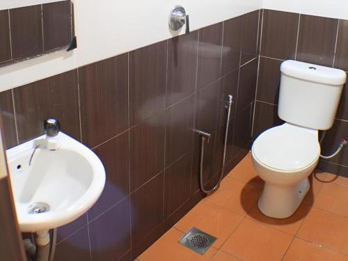 un baño con inodoro y lavabo en Taipann Hotel, en Kampong Telok Gadong Besar