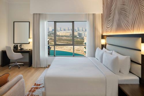 a hotel room with a large bed and a window at Marriott Hotel Production City, Dubai in Dubai