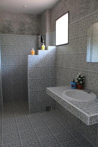 a bathroom with a sink and a mirror at Nananuira Apartment and Room in Khao Lak