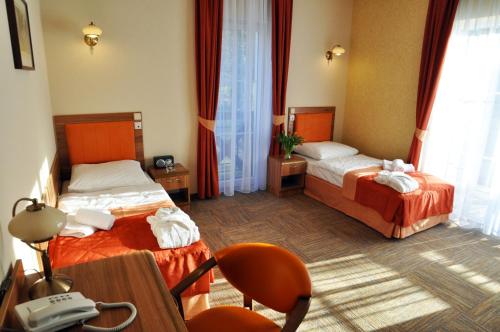 una camera d'albergo con due letti e un telefono di Uzdrowisko Połczyn Zdrój - Sanatorium Irena a Połczyn-Zdrój