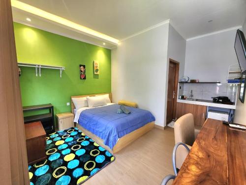 a bedroom with a bed and a green wall at Nana's Villa Sanur in Sanur