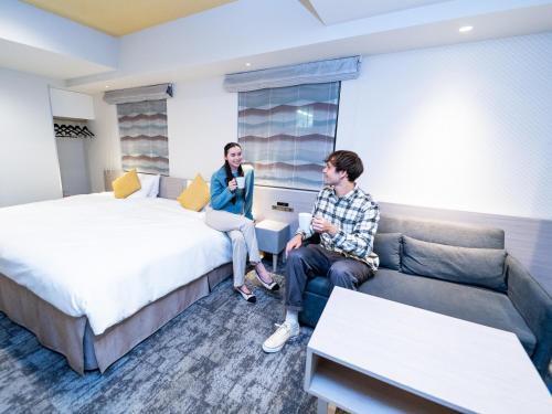 a man and a woman sitting in a hotel room at Tokyu Stay Suidobashi in Tokyo