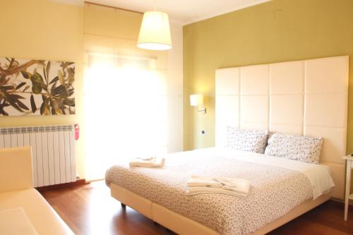 a bedroom with a large bed with a large white headboard at B&B da Peppe in Rotonda
