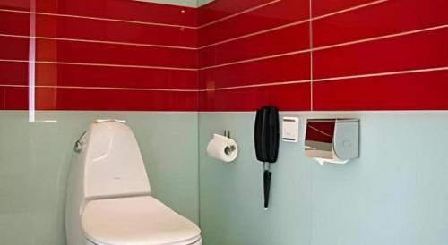 a bathroom with a toilet and a phone on the wall at Tomolo Hotel Wuzhan Branch in Wuhan