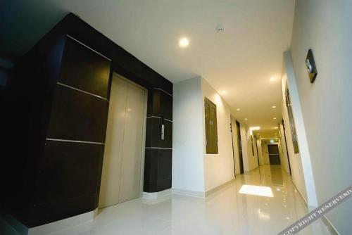 einen Flur mit schwarzer Tür in einem Gebäude in der Unterkunft Pannapat Place in Bangkok