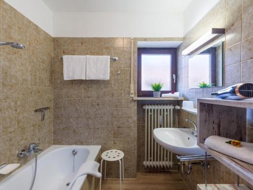 une salle de bains avec baignoire et lavabo dans l'établissement Zahmer Kaiser, à Oberaudorf