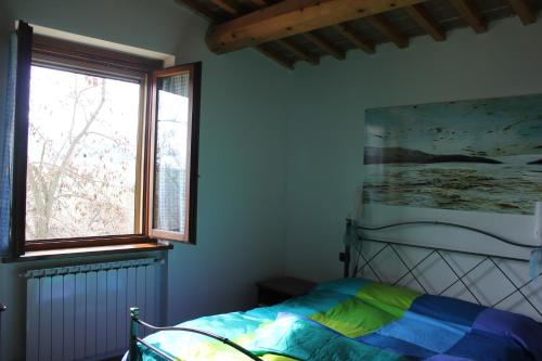 a bedroom with a bed and a large window at Agriturismo La Valle del Vento Urbino in Urbino