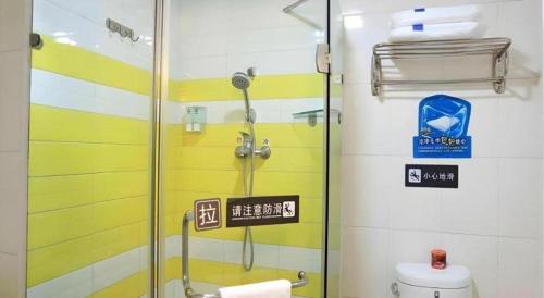 une douche avec une porte vitrée dans une salle de bain dans l'établissement 7 Days Inn Urumqi Guangming Road Beimen Metro Station, à Ürümqi