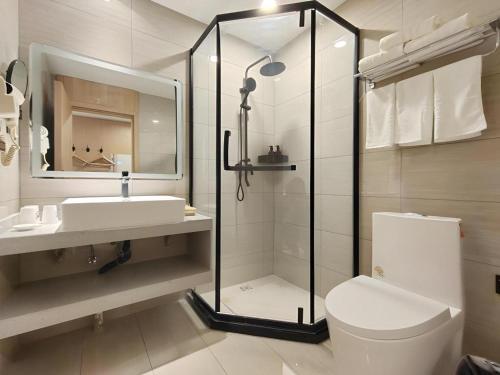 une salle de bains avec douche, toilettes et lavabo dans l'établissement GreenTree Inn Shanxi Jinzhong JieXiu Railway Station Express Hotel, à Jiexiu