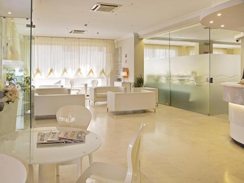 a waiting room with white chairs and a table at Hotel Radar in Rimini