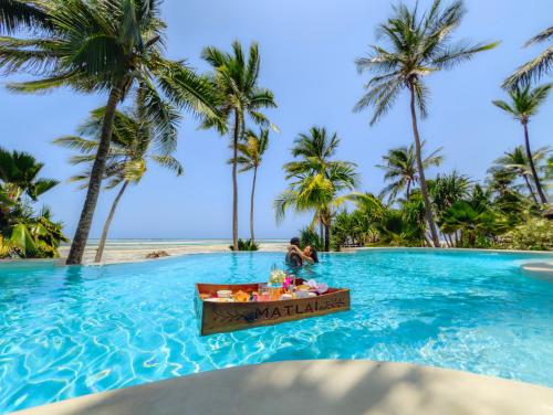 a table in the middle of a swimming pool at a resort at Boutique Hotel Matlai in Michamvi