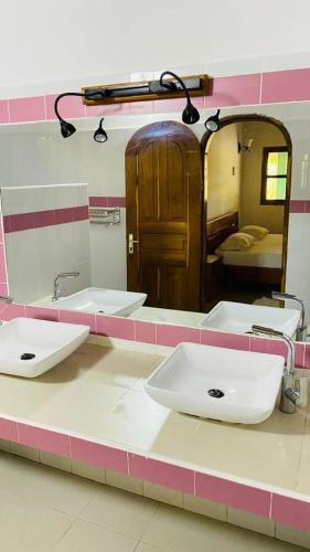 łazienka z dwiema umywalkami i lustrem w obiekcie Maison Diamota w mieście Kabrousse