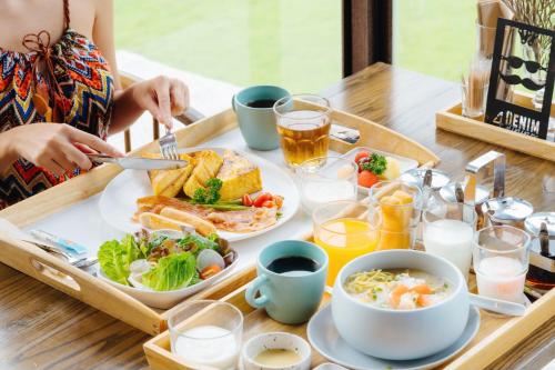 a tray of breakfast food on a wooden table at Wheeler Bed &Bike in Bangsaen