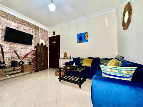 a living room with a blue couch and a tv at Nice apartment by the beach in Sale