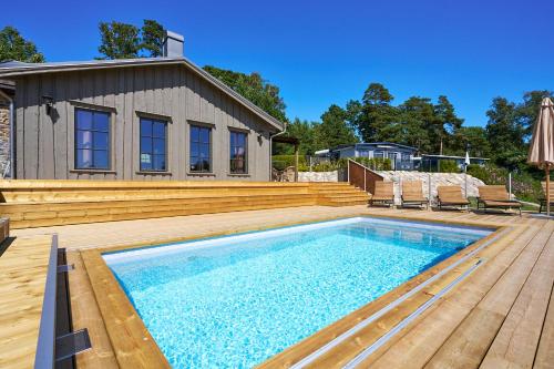einem Pool mit Holzterrasse und einem Haus in der Unterkunft Daftö Resort in Strömstad