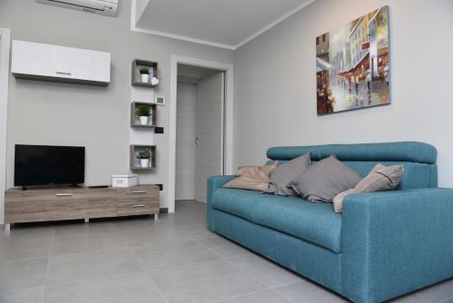a blue couch in a living room with a tv at Lingotto Residence in Turin