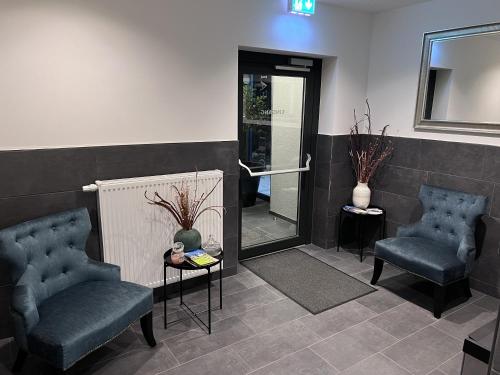 a waiting room with two chairs and a mirror at Hotel Falken in Hechingen