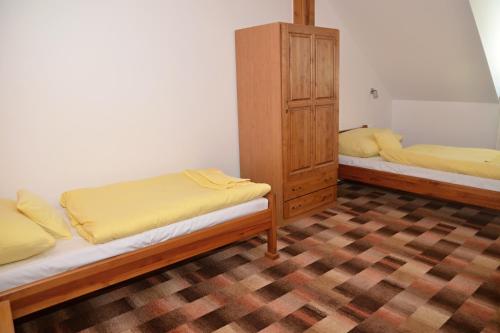 two beds in a room with yellow sheets on them at Hotel Na Statku in Nepřevázka