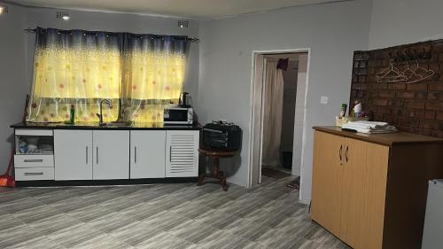 a living room with a counter and a window at Staylax guesthouse in Harare