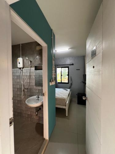 ein Badezimmer mit Waschbecken und ein Bett in einem Zimmer in der Unterkunft Flow stay koh samet 流宿 沙美島 in Ko Samed
