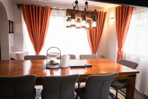 a dining room table with chairs and a large window at Bethel house in Ruiru