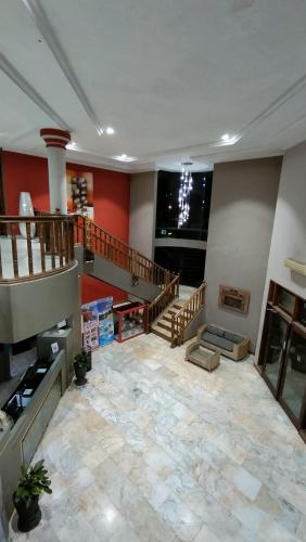 a large living room with a staircase and a large stone floor at Hotel Taufina Solok in Solok