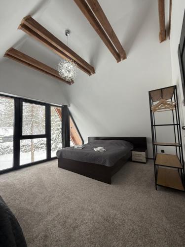 a bedroom with a bed in a room with windows at Luxusný CHALET DANIELS Tatranská Štrba in Štrba