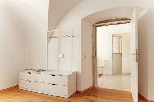 a white dresser in a room with a mirror at Gewölbezimmer am Hauptplatz 28 in Retz