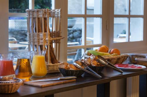 a table with baskets of food and drinks on it at Best Western Blanche de Castille Dourdan in Dourdan