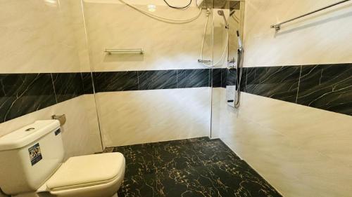 a bathroom with a toilet and a shower at The Secret Garden Sigiriya in Sigiriya