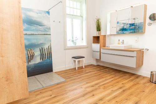 a bathroom with a sink and a mirror at Gulfhof Fresena in Norden