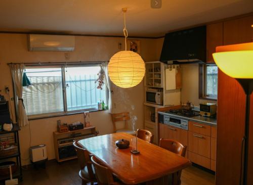 a kitchen with a wooden table and a lamp at 6minto Osaka sta Traditional home withJapanese Local in Osaka