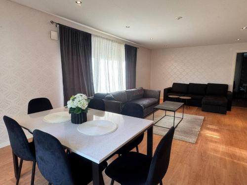 ein Wohnzimmer mit Tisch und Stühlen und einer Couch in der Unterkunft Family & Worker Accommodations in Göteborg in Olofstorp