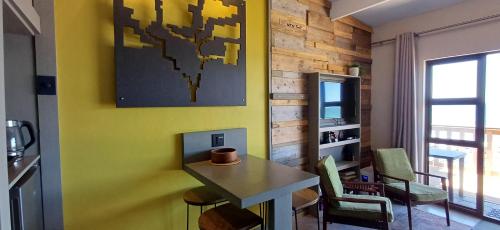 a room with a table and chairs and a television at Mitford Marula in Morganʼs Bay