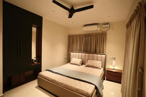 ein Schlafzimmer mit einem Bett mit Deckenventilator in der Unterkunft La Coast Beach Villa ECR in Tirupporūr