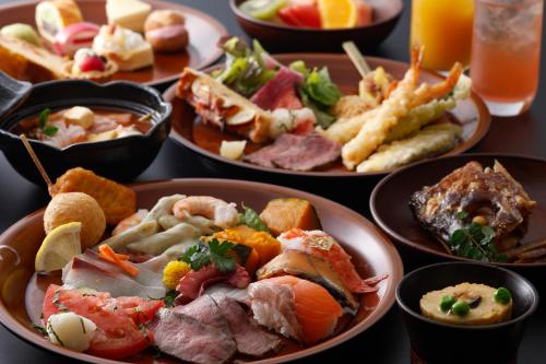 una mesa cubierta con platos de comida y tazones de comida en Arima Onsen Gekkoen Yugetsusanso, en Kobe
