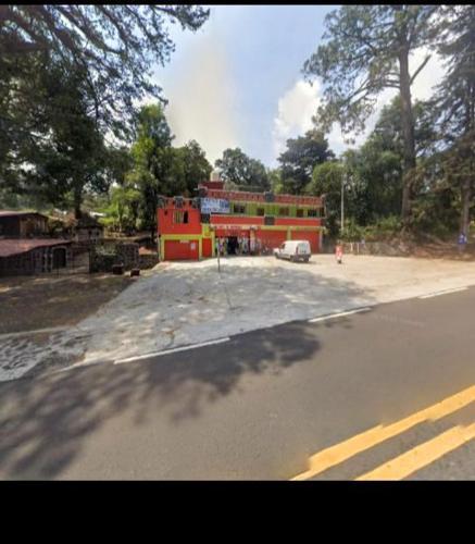 un edificio rojo al costado de una calle en Hotel Sierra Encantada, en Cuernavaca
