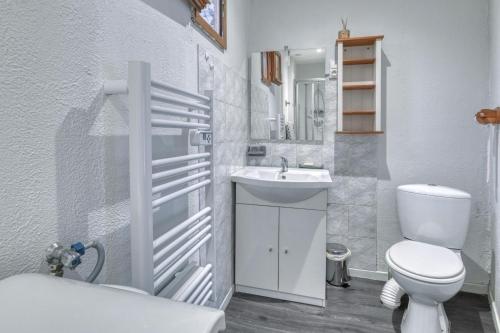 une salle de bains blanche avec toilettes et lavabo dans l'établissement Studio Le Laurier, à Lherm