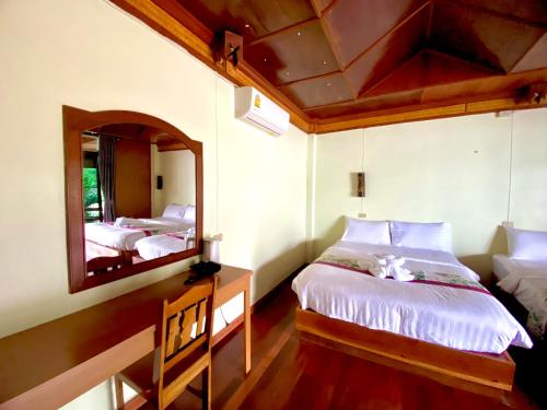 een slaapkamer met twee bedden en een spiegel bij Family view A2 in Ko Bu Bu