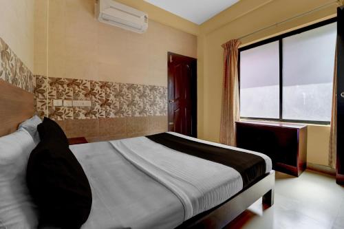 a bedroom with a bed and a large window at Collection O KSRTC Bus Station Kottayam Formerly Hotel O Day Springs in Kottayam