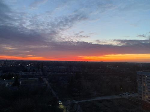 una vista de la ciudad al atardecer con el cielo en Стильна, затишна, простора квартира в центрі, en Cherkasy