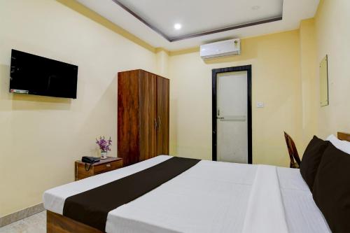a bedroom with a large bed and a television at Collection O Asian Highway Near Agrasen Hospital Siliguri Formerly Ashiyana Homestay in Binnāguri