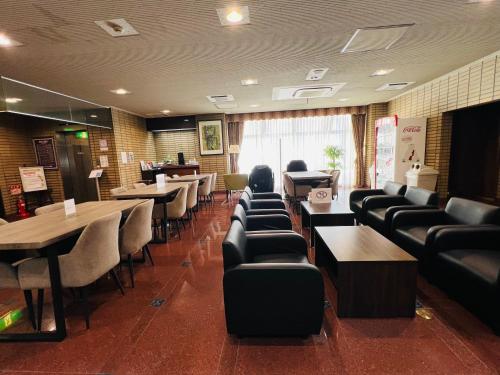 a restaurant with couches and tables and chairs at Hotel Crown Hills Sagamihara in Sagamihara