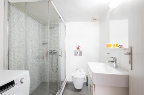 a bathroom with a shower and a toilet and a sink at Renovated 4 Bdr House near Acropolis - New Beds, Terrace & Green Yard in Athens