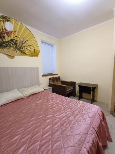 1 dormitorio con 1 cama rosa grande y 1 silla en 1 комн квартира, свой двор, en Cherkasy