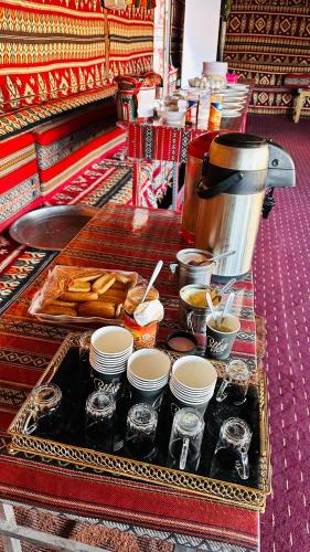 une table avec un plateau de nourriture et une cafetière dans l'établissement Desert guide camp, à Wadi Rum